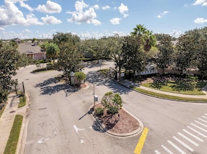 A residential street with a gated entrance, a roundabout, and a building labeled 'CAYMAN'. - Star Wars & Mickey Kids Rooms | 18 Min to Disney (Kissimmee)