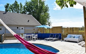 A pool area with a hammock, lounge chairs, and a covered seating area. - Cozy home in ängelholm with private swimming pool, can be inside or outside (Ängelholm)