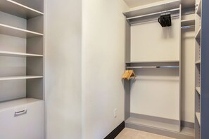 Um closet amplo com prateleiras abertas e cabideiro.