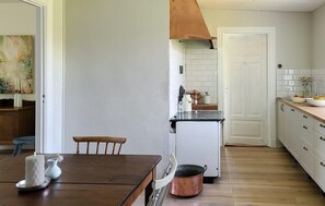 A kitchen with a wooden table, a white refrigerator, and a copper pot. - 4 bedroom gorgeous home in Visselfjärda (Visselfjärda)