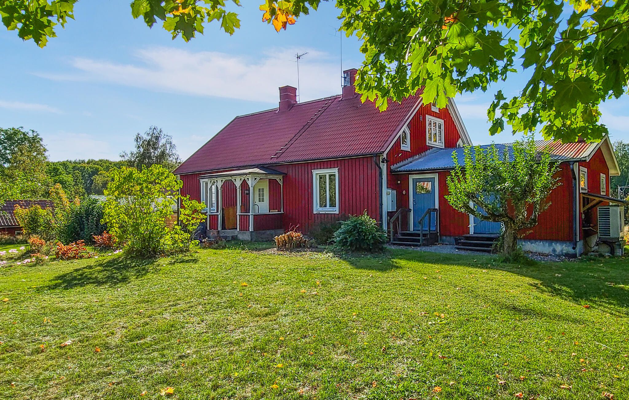 A red house with a porch and a small garden.