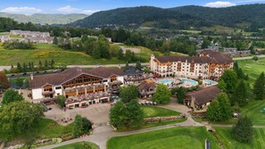 Un resort con diversi edifici, una piscina e un campo da golf.