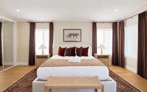 A spacious bedroom with a large bed, two bedside tables, a bench, and a framed animal silhouette on the wall. - Sundance - Private Pool - Mins to Kierland Commons (Scottsdale)