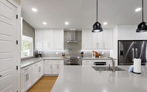 A modern kitchen with white cabinets, stainless steel appliances, and pendant lighting. - Sundance - Private Pool - Mins to Kierland Commons (Scottsdale)