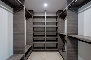 A modern closet with multiple shelves and a hanging rod, featuring a minimalist design and neutral color palette. - Sundance - Private Pool - Mins to Kierland Commons (Scottsdale)