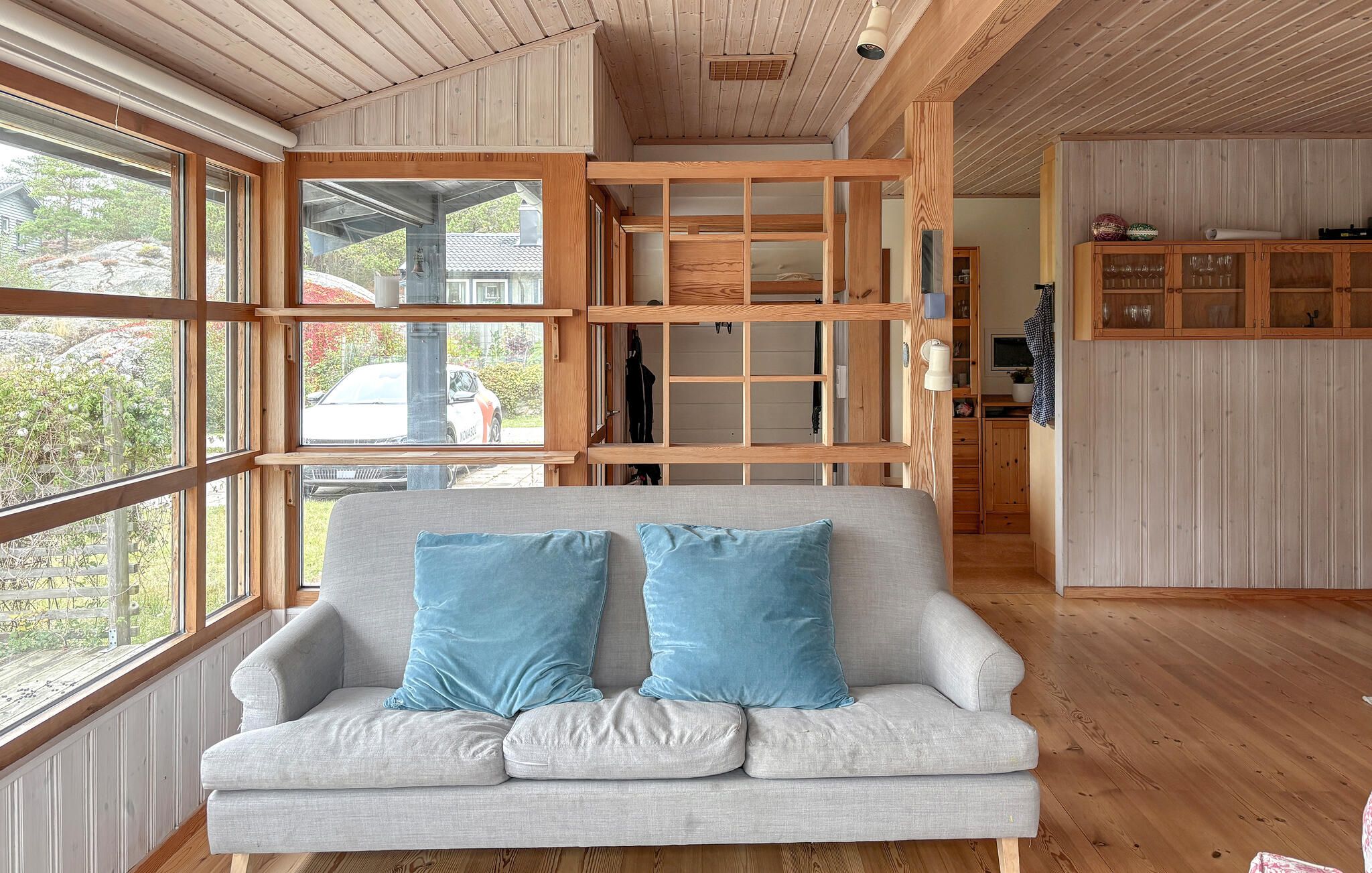 A room with a sofa, wooden beams, and a view of the outside.