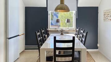 A dining area with a table, chairs, and a pendant light.