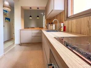 Eine moderne Küche mit Holzarbeitsplatte, eingebautem Backofen und Pendelleuchten.