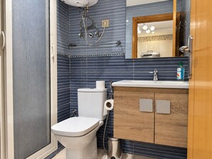 A bathroom with a toilet, sink, and shower. - Guéliz - Stylish Apartment with Balcony (Marrakesh)