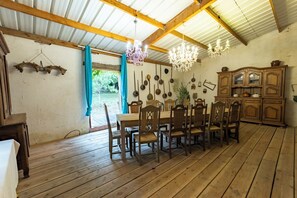 A rustic dining area with wooden furniture, a chandelier, and a view of the outdoors. - Exclusive Estate - La Chapelle aux Acacias (Caucalières)