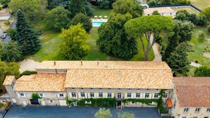 A large building with a tiled roof, surrounded by lush greenery and a swimming pool. - Exclusive Estate - La Chapelle aux Acacias (Caucalières)