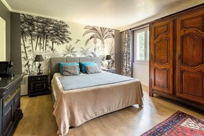 A bedroom with a bed, nightstands, a dresser, a large wardrobe, and a tropical mural on the wall. - Exclusive Estate - La Chapelle aux Acacias (Caucalières)