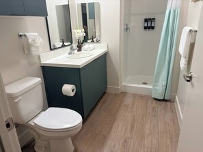 Ein modernes Badezimmer mit Toilette, Waschbecken und Duschbereich.