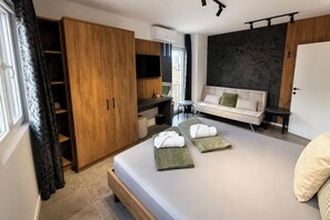 Un dormitorio moderno con cama, sofá, armario y una mesita.