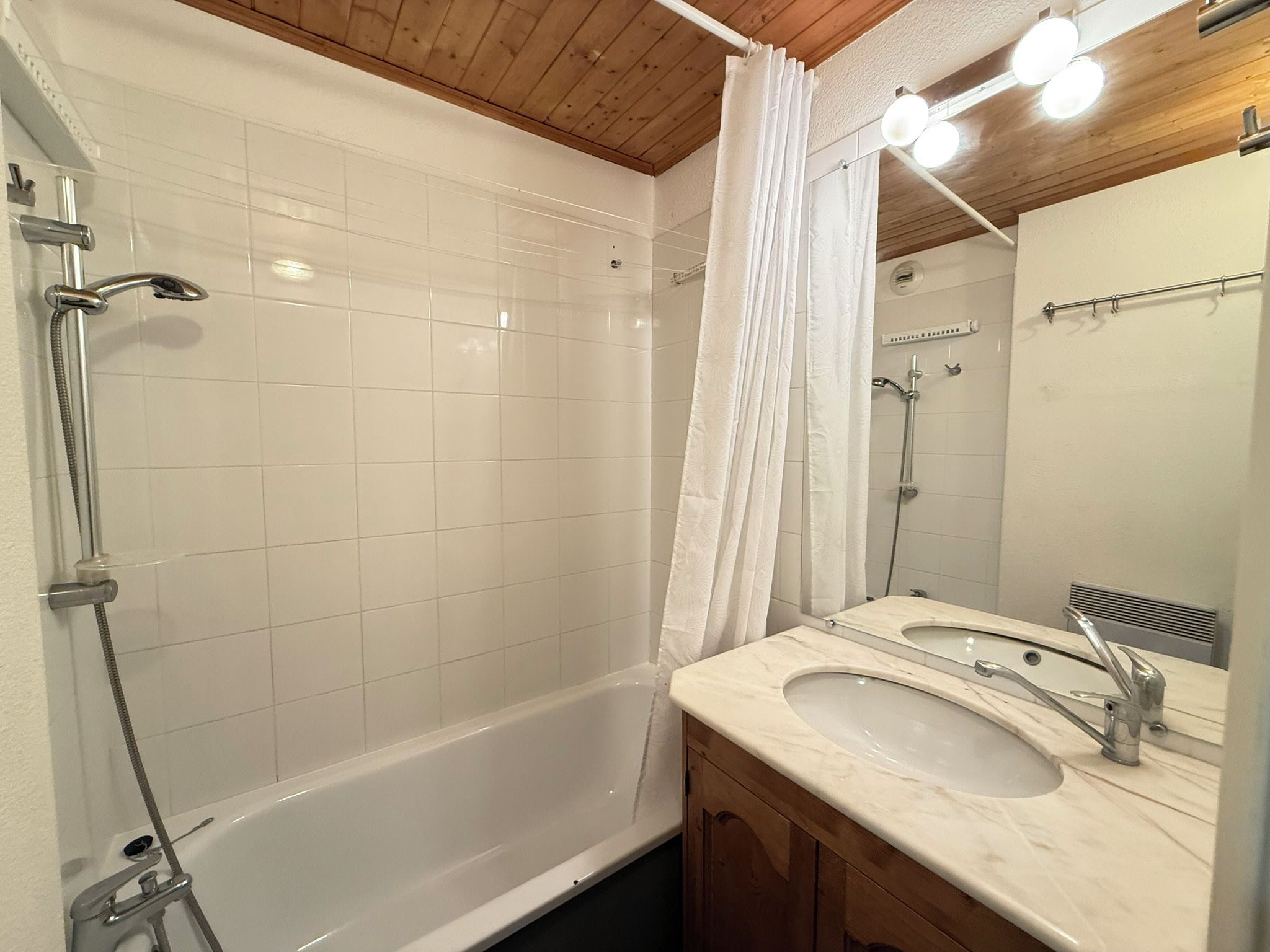 Un bagno con una vasca, due lavandini, una doccia e uno specchio.