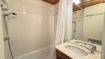 Un bagno con una vasca, due lavandini, una doccia e uno specchio.