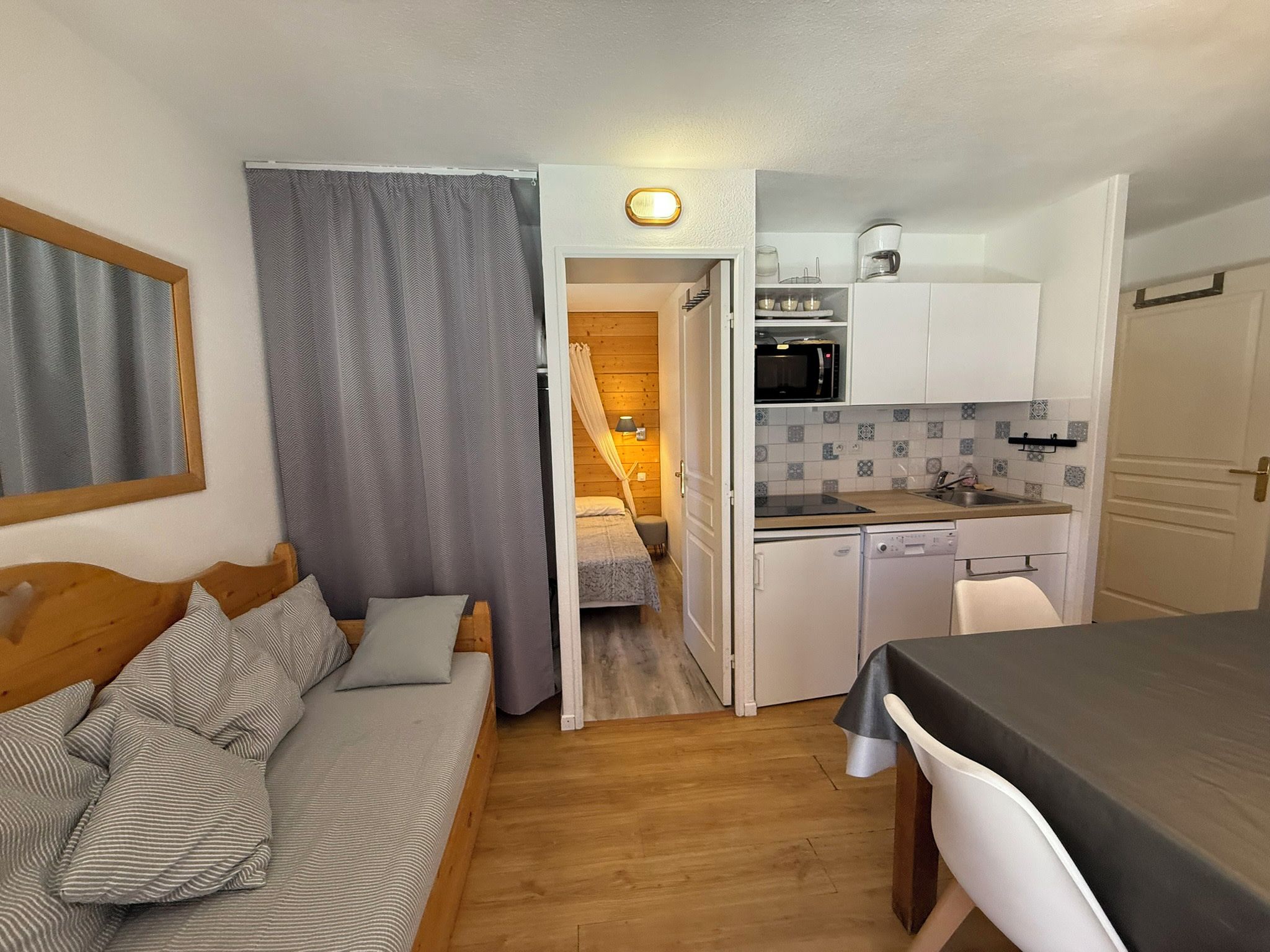 Ein kompakter Wohnraum mit Küchenzeile, Essbereich und Schlafzimmer.