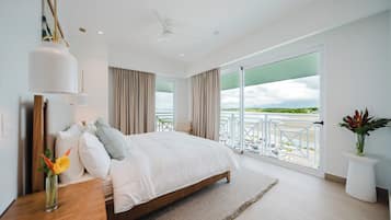 Una camera da letto moderna con un letto grande, vista sull'esterno e un balcone con ringhiera.