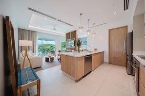 Una cocina moderna con una isla central, electrodomésticos integrados y un amplio ventanal con vistas a zonas verdes.