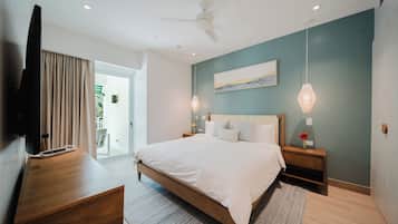 Una camera da letto moderna con un letto, comodini, una televisione e una ventola a soffitto.