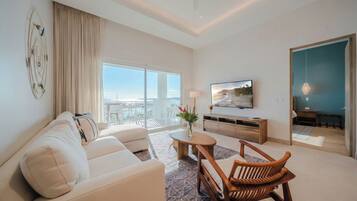 A modern living room with a sofa, a wooden chair, a coffee table, and a TV.