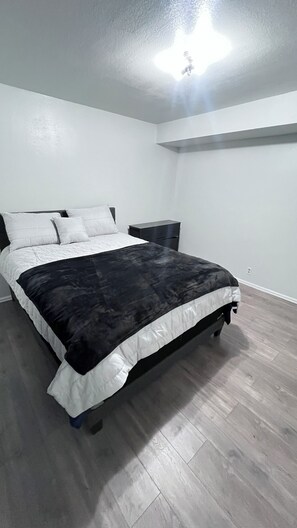 Ein Schlafzimmer mit Bett, Nachttisch und einer Lampe.