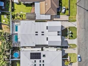 Un edificio residenziale con tetto piatto, piscina e pannello solare.