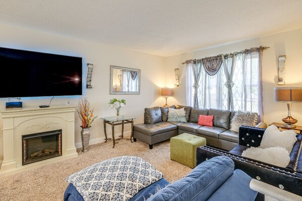 A living room with a fireplace, a television, a sofa, a loveseat, and a coffee table. - Spacious 5BR Home for Families & Groups (Fort Washington)