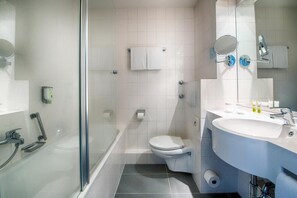 Un bagno moderno con cabina doccia in vetro, un water bianco, un lavandino con specchio e un portasciugamani.