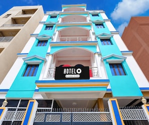 A hotel building with a prominent sign indicating it is a company-serviced establishment.