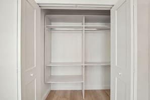 A walk-in closet with white shelving units and a wooden floor. - NEW! Cool Breeze - 1 Mile to Vanderbilt Beach! - Heated Pool - Southern Exposure (Naples)