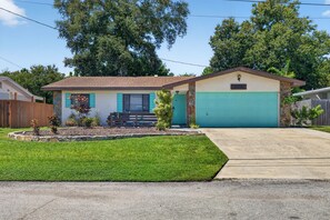 A single-story house with a front garage, a small porch, and a well-maintained lawn. - Heated Private Pool House Minutes From Indian Rocks Beach (Largo)