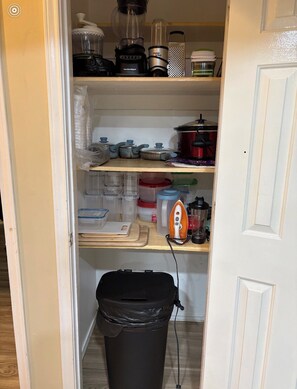 A kitchen pantry with storage containers, a blender, a kettle, and a trash bin. - Spacious 4-bedroom house in lovely Weslaco with AC (Weslaco)