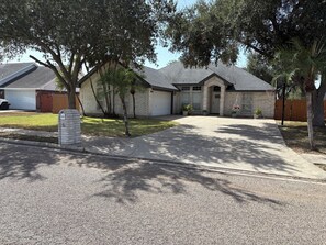 A residential house with a driveway, a mailbox, and a lawn. - Spacious 4-bedroom house in lovely Weslaco with AC (Weslaco)