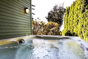 A hot tub with a wooden deck and a hedge in the background. - Water & Gulf Islands Views, Beach Access, Hot Tub, Game Room (Bellingham)