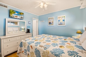 A bedroom with a bed, dresser, vanity, and a ceiling fan. - Sunrise Symphony  pool, ocean views, and beach access (Duck)
