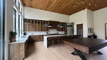 A modern kitchen with wooden cabinets, a central island, and pendant lighting.
