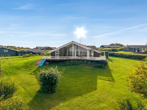 A residential property with a large lawn, a deck, and a slide. - "Taneli" - 400m from the sea by Interhome (Glesborg)