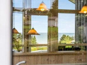 A view through a window with a wooden frame, a clear sky, and a body of water in the distance. - "Taneli" - 400m from the sea by Interhome (Glesborg)