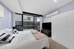 A modern bedroom with a bed, a TV, and a wardrobe. - Modern 1-bedroom Apartment in the Heart of Footscray (Melbourne)
