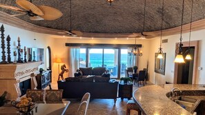 A spacious living area with a fireplace, a sofa, and a dining area with a view of the ocean. - Front Row to the Beach - 5 BR Bella Sirena Villa (Puerto Peñasco)