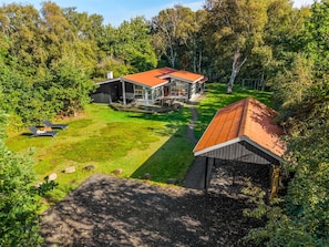 A modern house with a large deck and a covered outdoor area, surrounded by dense trees. - "Aisa" - 200m from the sea by Interhome (Ebeltoft)