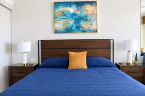 A hotel room with a large bed, two bedside tables, a nightstand, a wall-mounted painting, and a window. - 15th Floor Stunning Studio Condo in Sonoran Star (Puerto Peñasco)
