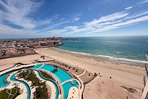 Ein Resort mit großem Swimmingpool, direkt am Strand und Blick auf den Ozean.