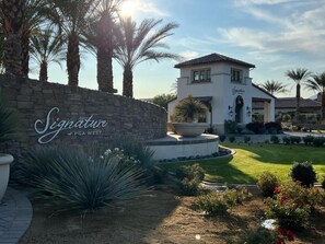 Ein Gebäude mit einer Steinsäule und einem Schild, das 'Signature at PGA West' zeigt.