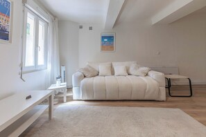 A minimalist bedroom with a bed, a bedside table, a small desk, and a poster on the wall. - L' Azur du Mourillon 5 minutes from the beach - Welkeys (Toulon)