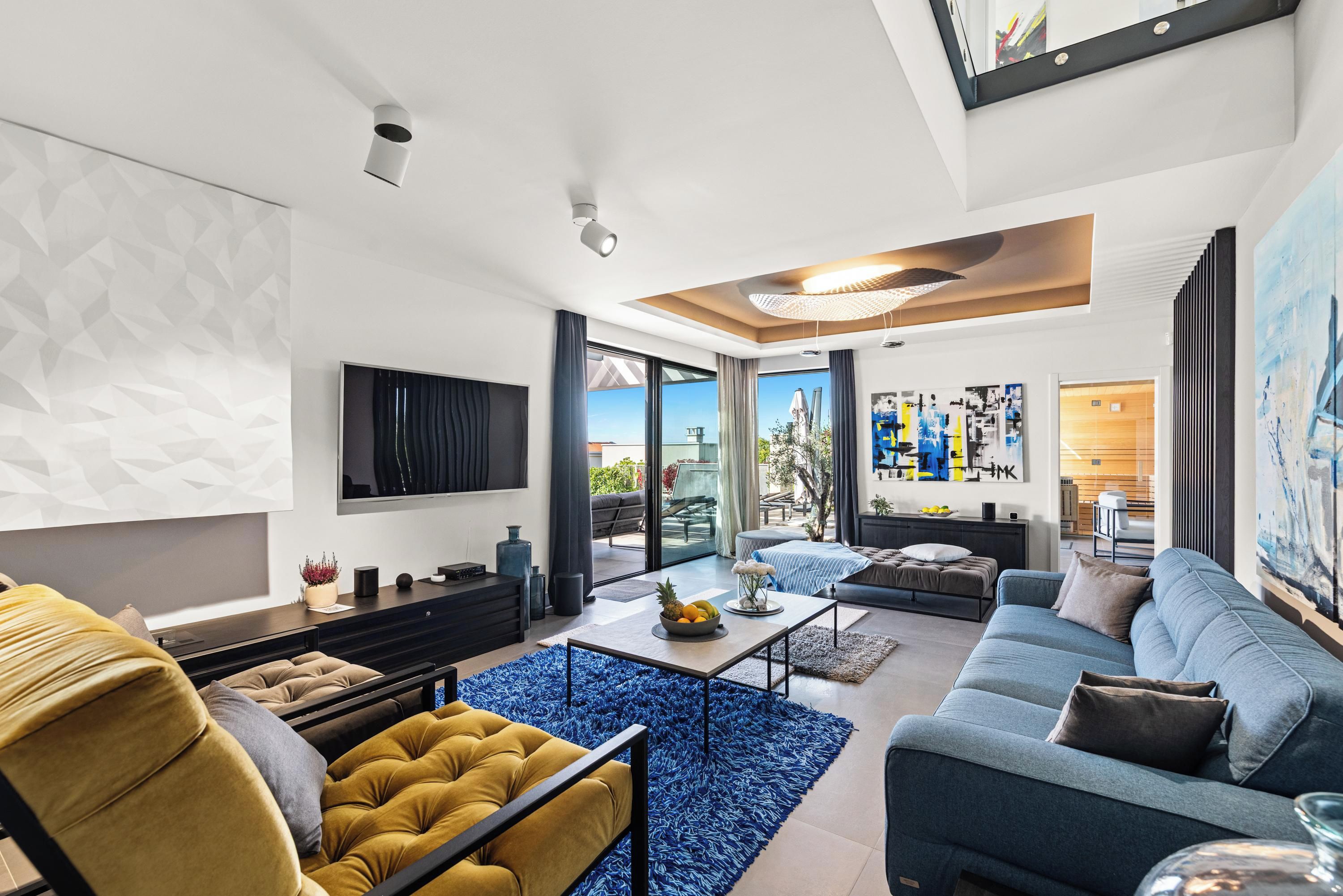 A modern living room with a sofa, a coffee table, and a TV mounted on the wall.