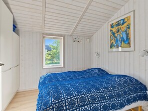 A room with a bed, a window, a painting, and a wall-mounted light fixture. - "Sighrik" - 600m from the sea by Interhome (Stubbekøbing)