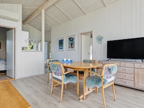 A dining area with a wooden table and chairs, a television, and artwork on the walls. - "Sighrik" - 600m from the sea by Interhome (Stubbekøbing)