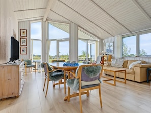 A spacious living area with a high ceiling, large windows, and a dining table with chairs. - "Sighrik" - 600m from the sea by Interhome (Stubbekøbing)